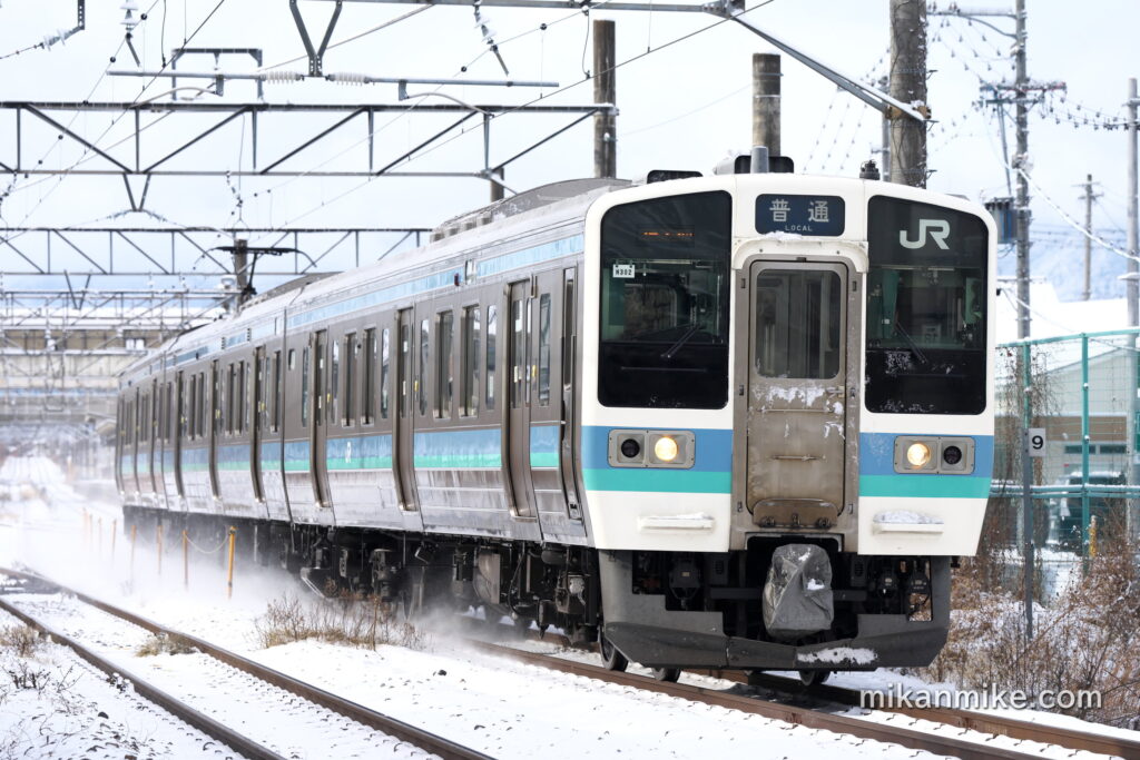 雪を巻き上げて走る211系長野色